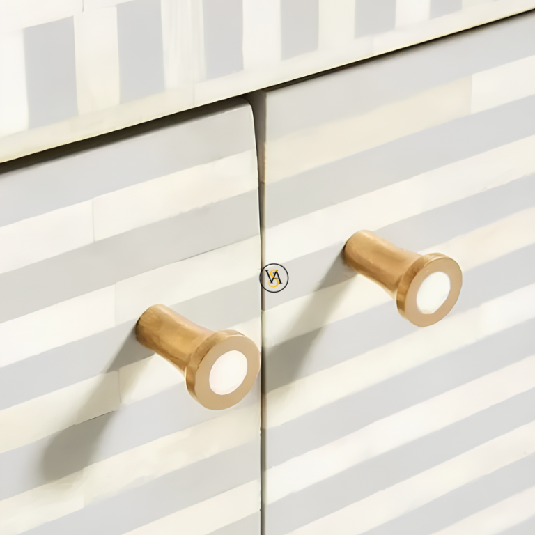Detailed view of brass metal cabinet handles on a striped bone inlay cabinet door.