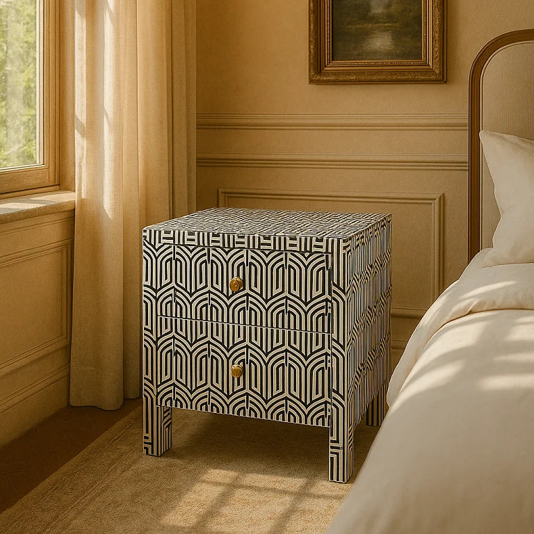 A black bone inlay bedside table with a geometric design, placed in a room beside a bed with a white cover.
