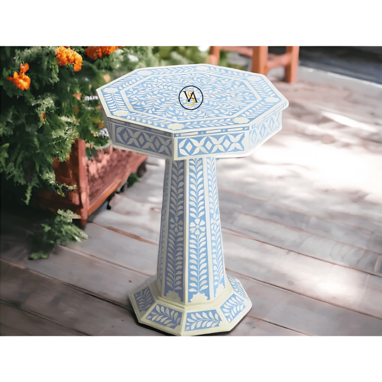 Handmade bone inlay floral pedestal side table placed outdoors beside marigolds
