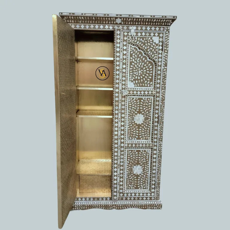 Partially open cupboard showing embossed brass details