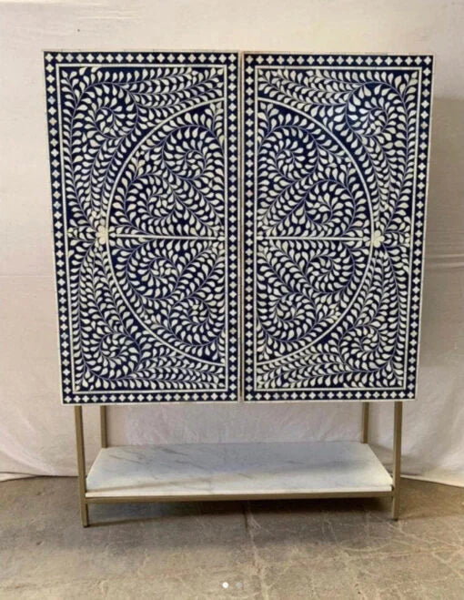 Closed view of navy blue floral bar cabinet with white bone inlay and brass base frame