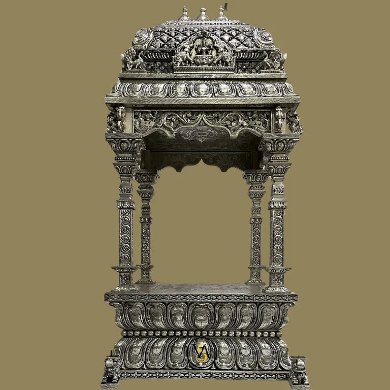 Full frontal view of a majestic white metal pooja mandir with traditional carvings.