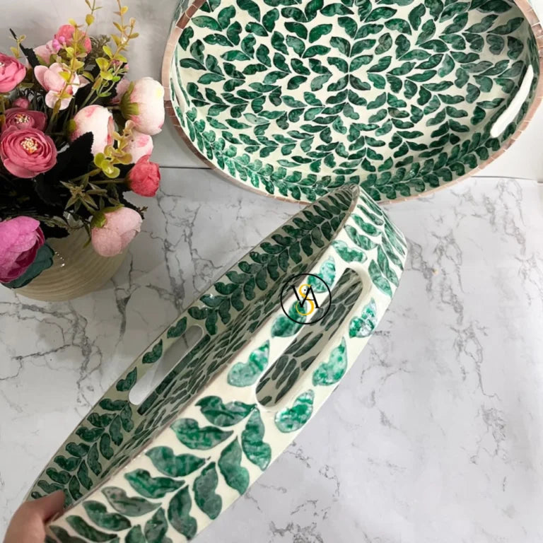 Close-up of side handles of green leaf inlay tray with white background