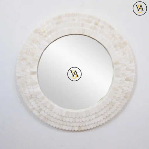 Round mirror with a decorative white shell frame on a light gray background