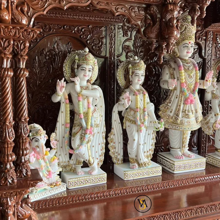 Close-up of marble deity idols in wooden mandir
