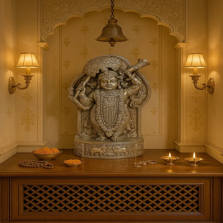 A Pure Silver Shreenathji Idol, depicting the divine deity Shrinathji, placed on a table with decorative items and candles around it, set against a wall with intricate designs.