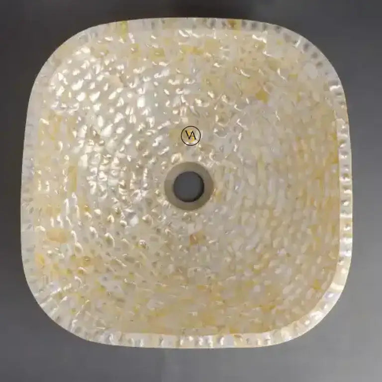 Square sink with textured surface and visible brand logo on a dark background