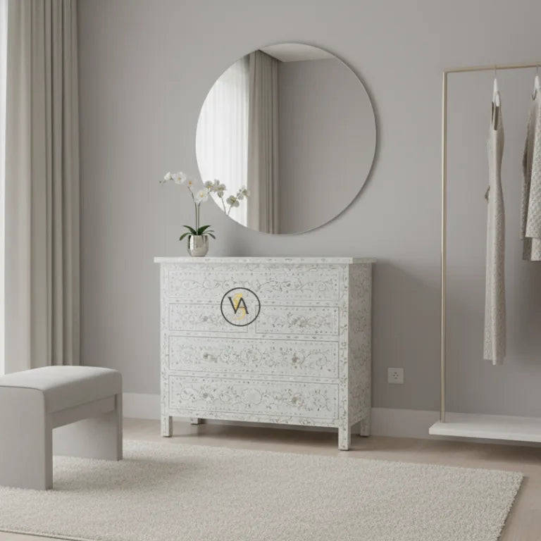 White textured mother of pearl dresser with round mirror and bench in a room.