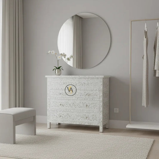 White textured mother of pearl dresser with round mirror and bench in a room.