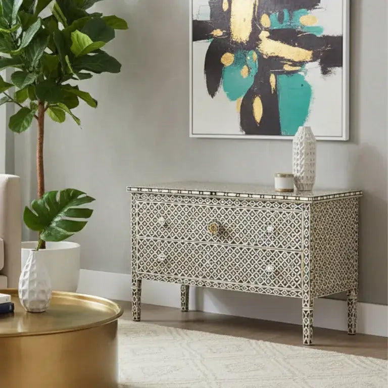 Bone inlay chest of drawers in a living room with plants and abstract art.