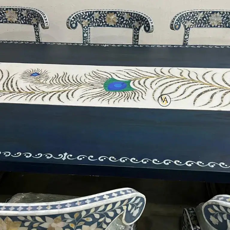 Decorative table with peacock feather design and chairs in the background