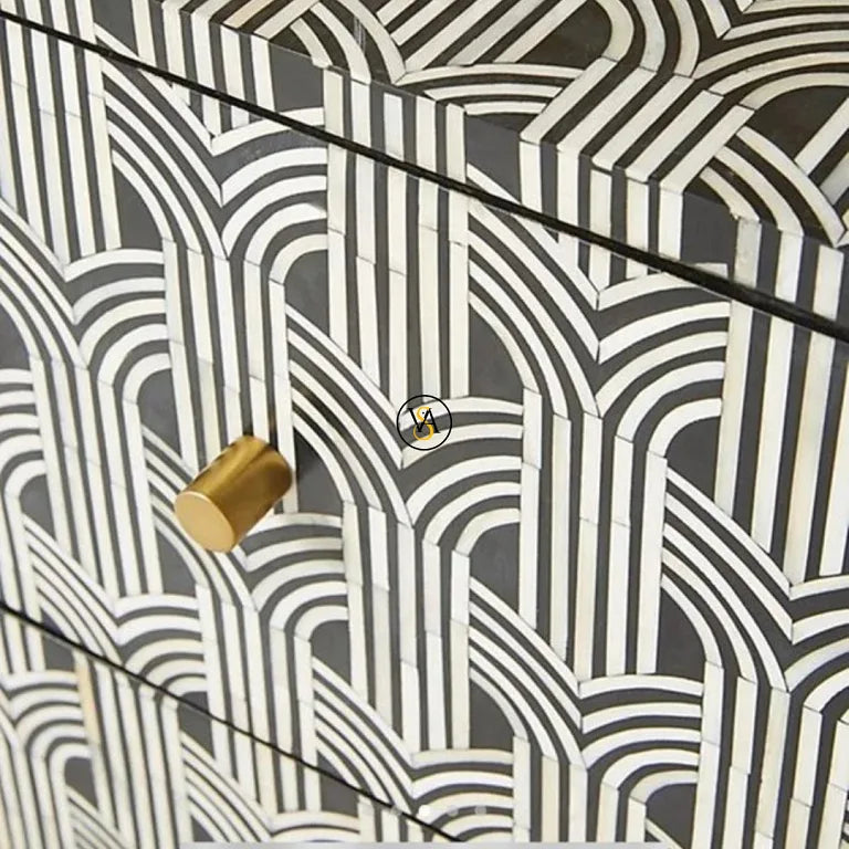 Close-up of bone inlay pattern with brass knob on black and white geometric bedside table