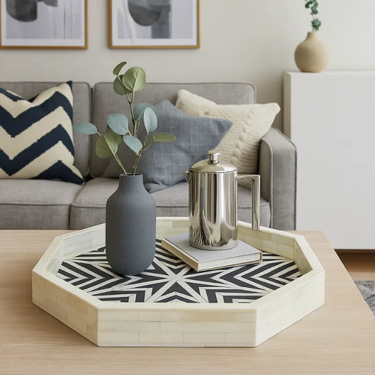 Decorative bone inlay hexagonal tray with a vase, books, and a metallic pitcher on a coffee table in a living room.