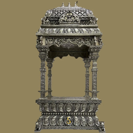 Full frontal view of a majestic white metal pooja mandir with traditional carvings.

