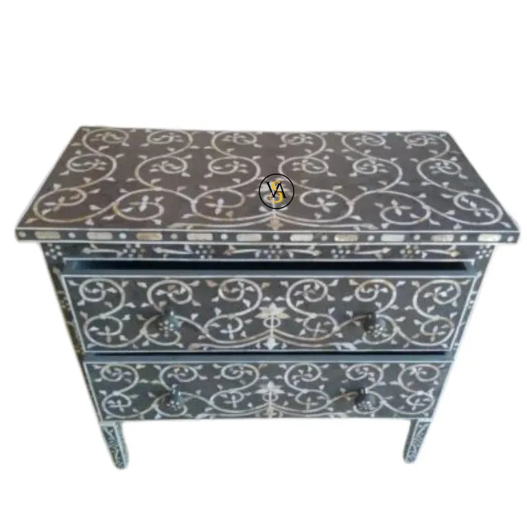 Decorative chest of drawers with intricate white patterns on a gray background