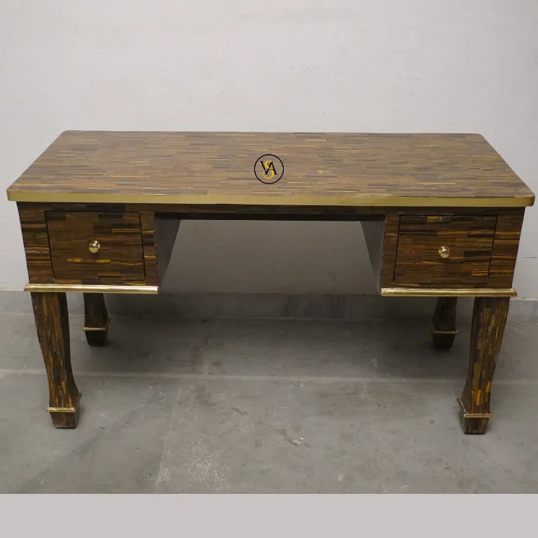 Mother of pearl writing table with two drawers on a concrete floor against a white wall