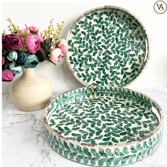 Round mother of pearl inlay tray with green leaf pattern on marble background