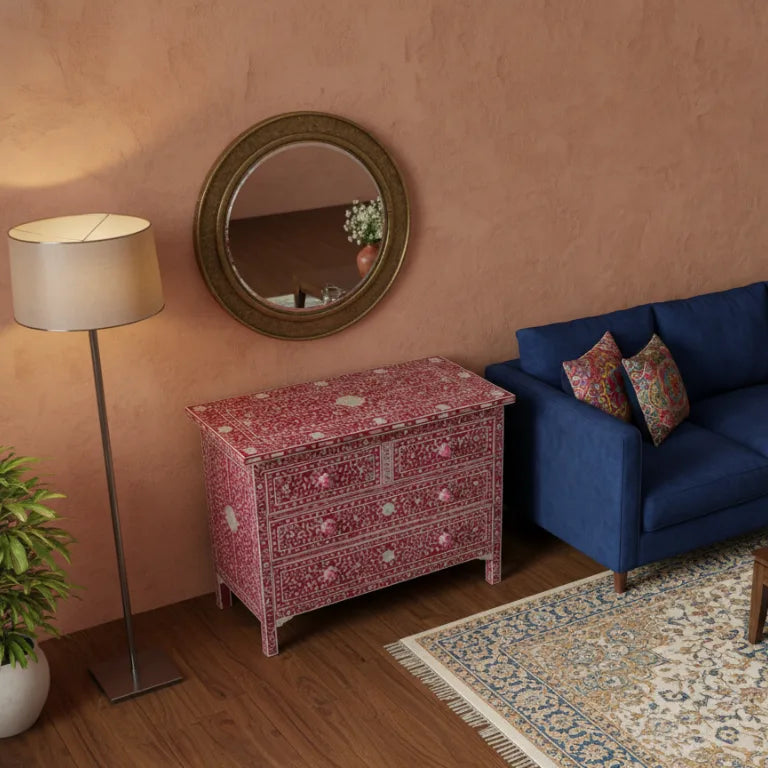 Beautiful Mother of Pearl Pink Chest of Drawers in living room setup with a blue sofa, and round mirror on a pink wall.