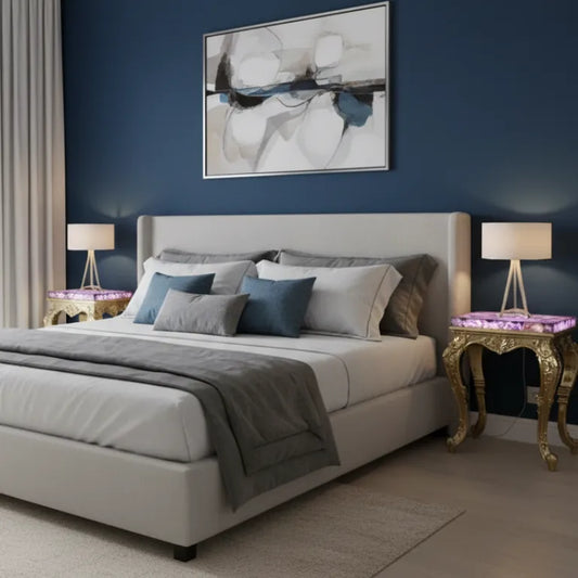 Modern bedroom with a bed, brass cladding side tables with amethyst, and abstract art on the wall.